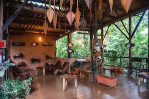 Un interior rústico de madera con techo de madera, estantes con zapatos y una zona de bancos.