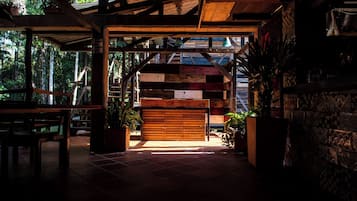 An interior space with a wooden bench, a tiled floor, and a view of the outdoors.
