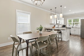A modern kitchen with white cabinets, a central island, and pendant lighting. - Bear's Den - 2.3 mi to DT-Direct MTB Trail Access (Bentonville)