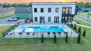 A modern building with a swimming pool, surrounded by a fence and small trees. - Bear's Den - 2.3 mi to DT-Direct MTB Trail Access (Bentonville)