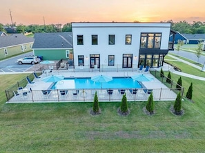 A modern building with a swimming pool, surrounded by a fence and small trees. - Bear's Den - 2.3 mi to DT-Direct MTB Trail Access (Bentonville)