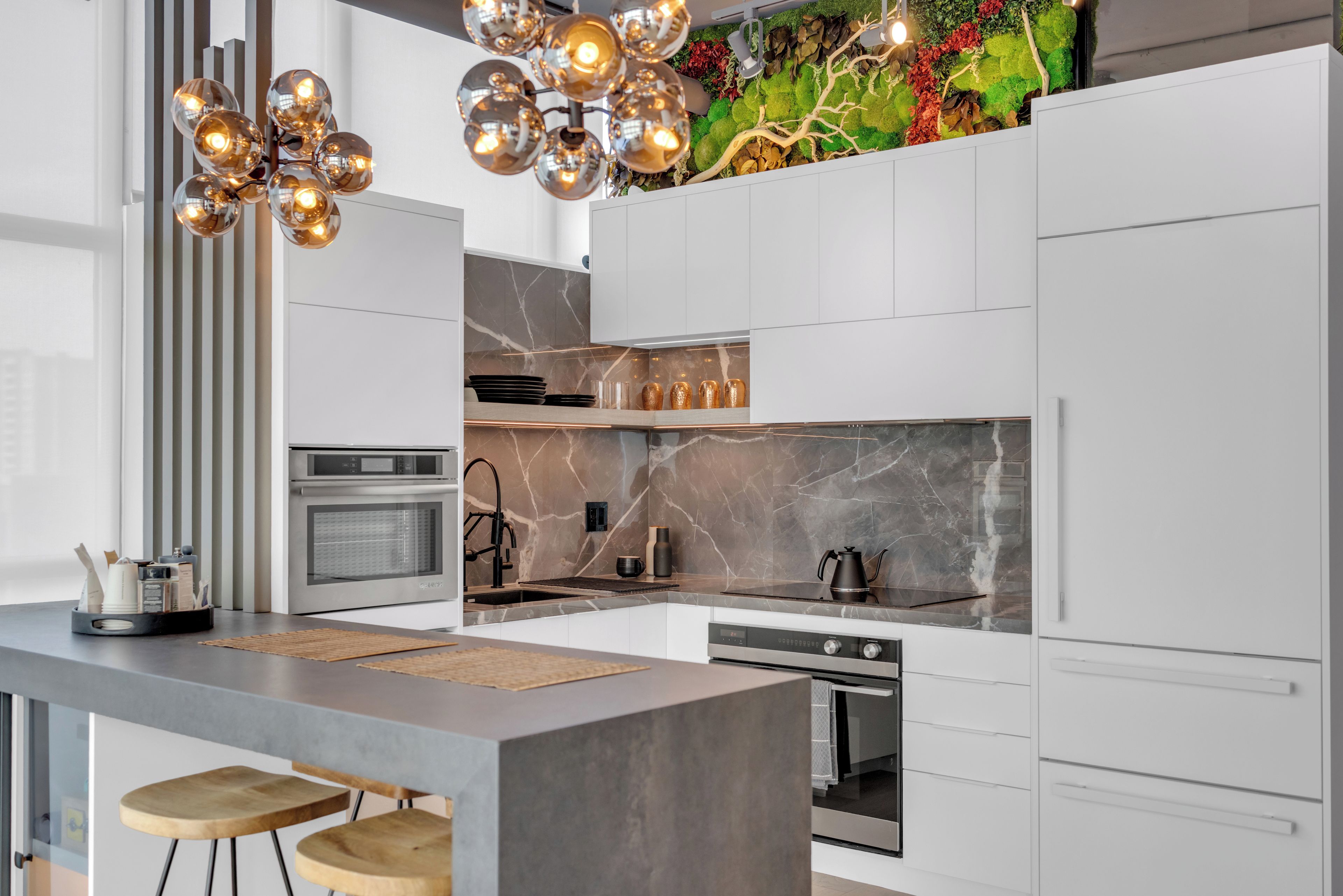 A modern kitchen with a central island, built-in oven, and a decorative backsplash.