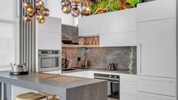 A modern kitchen with a central island, built-in oven, and a decorative backsplash.