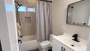 A bathroom with a bathtub, toilet, and sink.
