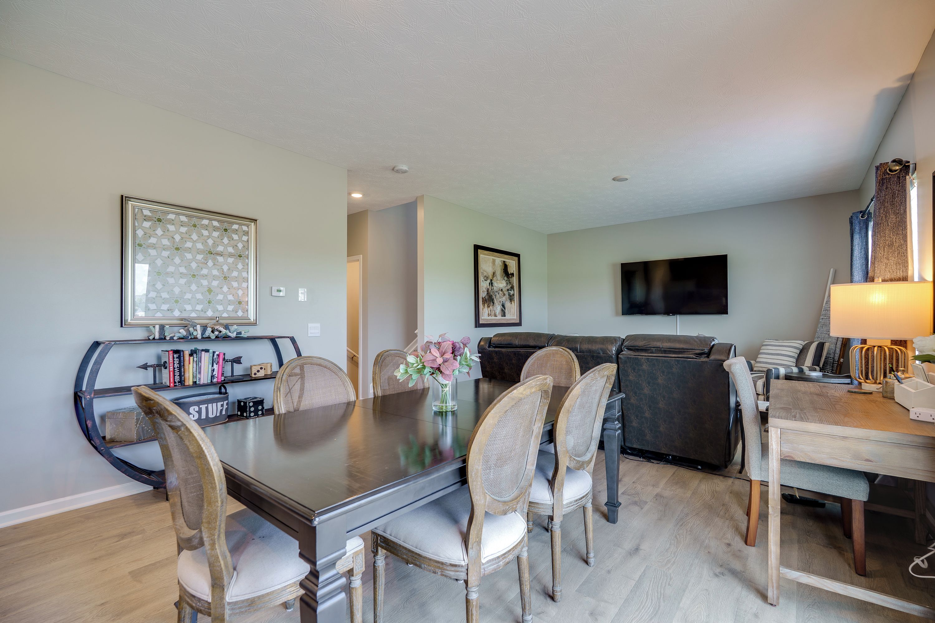 A dining area with a large table, chairs, and a bookshelf.