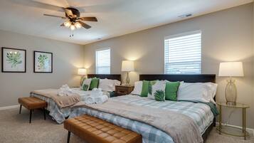 A bedroom with two beds, a ceiling fan, and two bedside lamps.