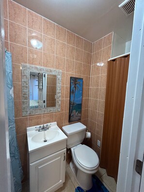 Un baño con lavamanos, inodoro y espejo.