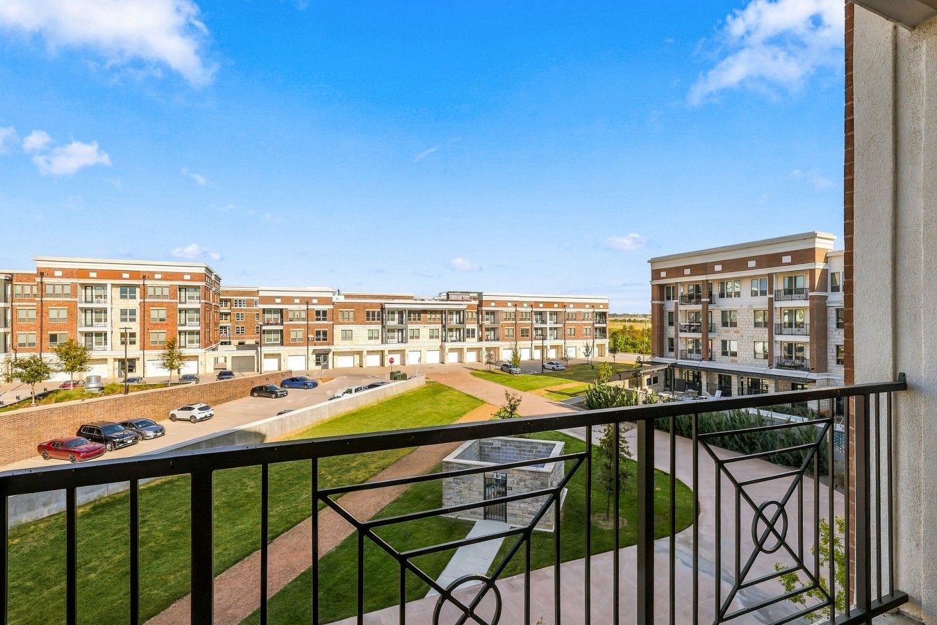 A residential building with multiple floors, a parking area, and a well-maintained lawn.