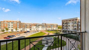 A residential building with multiple floors, a parking area, and a well-maintained lawn.