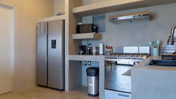 Una cocina moderna con refrigerador, microondas y estufa integrados.
