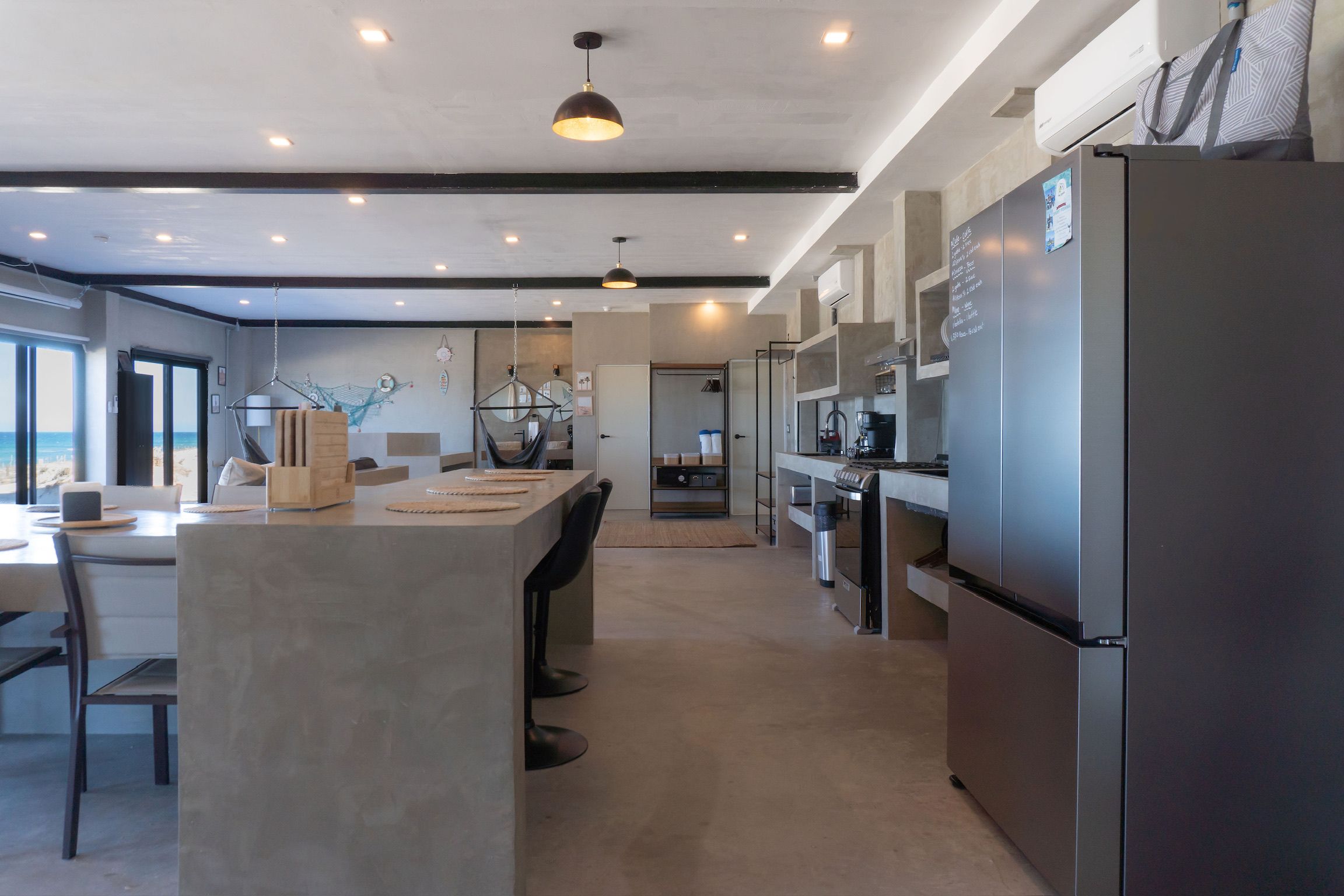A modern kitchen with a central island, stainless steel appliances, and a view to the outside.