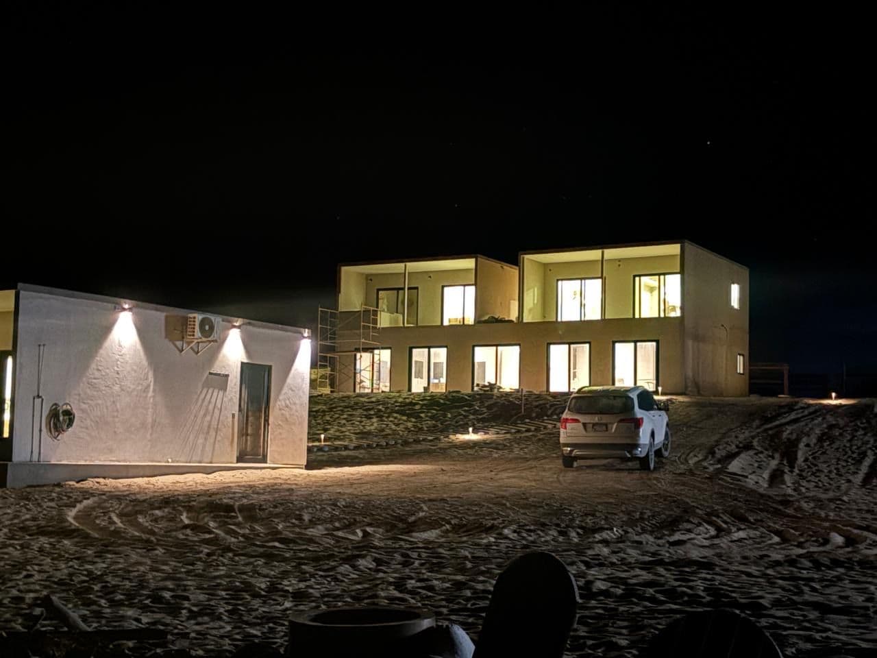 Een modern gebouw met meerdere ramen en een voertuig ervoor geparkeerd.