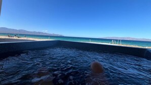 Un bain à remous avec vue sur une plage et des montagnes.