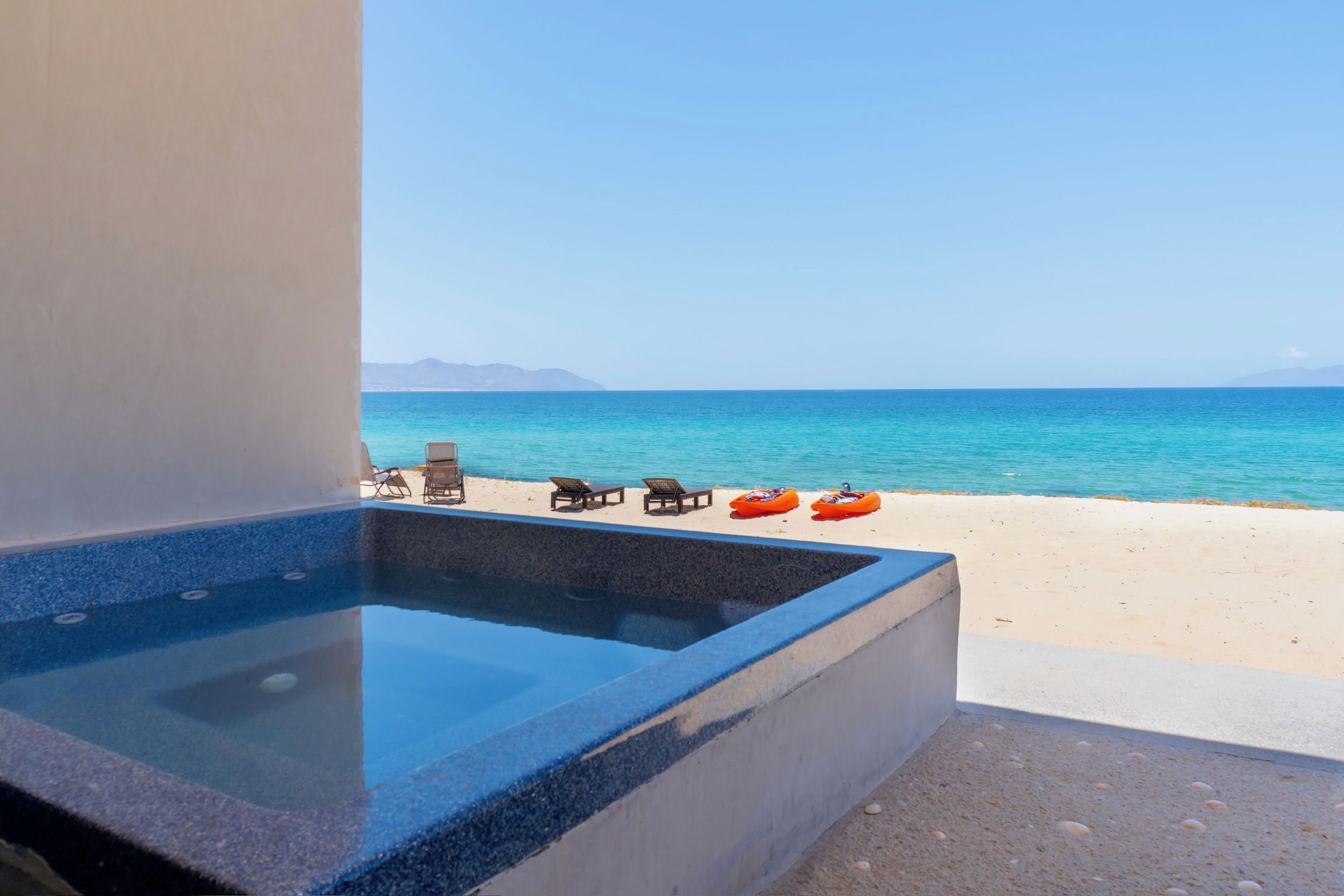 Zona de piscina con vistas al mar y a las montañas.