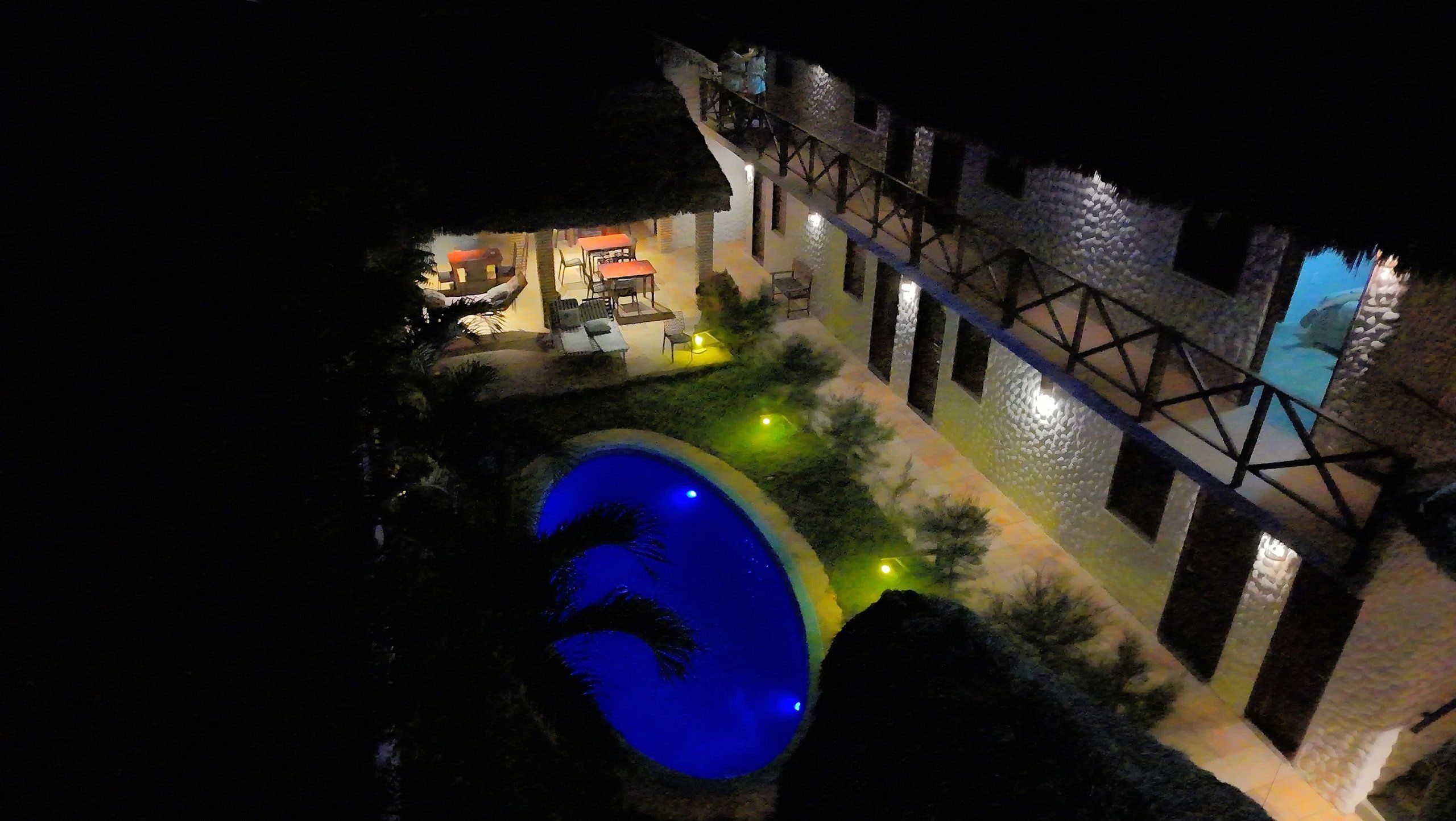 Uma área de piscina com piscina azul, assentos externos e uma estrutura de ponte.