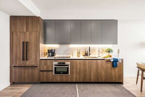 A modern kitchen with wooden cabinets, a Bosch oven, a coffee maker, and a sink. - Miami Beach Retreat Steps from the Shore (Miami Beach)