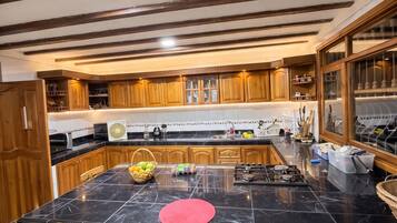 A kitchen with a large island, wooden bar stools, and a gas stove.