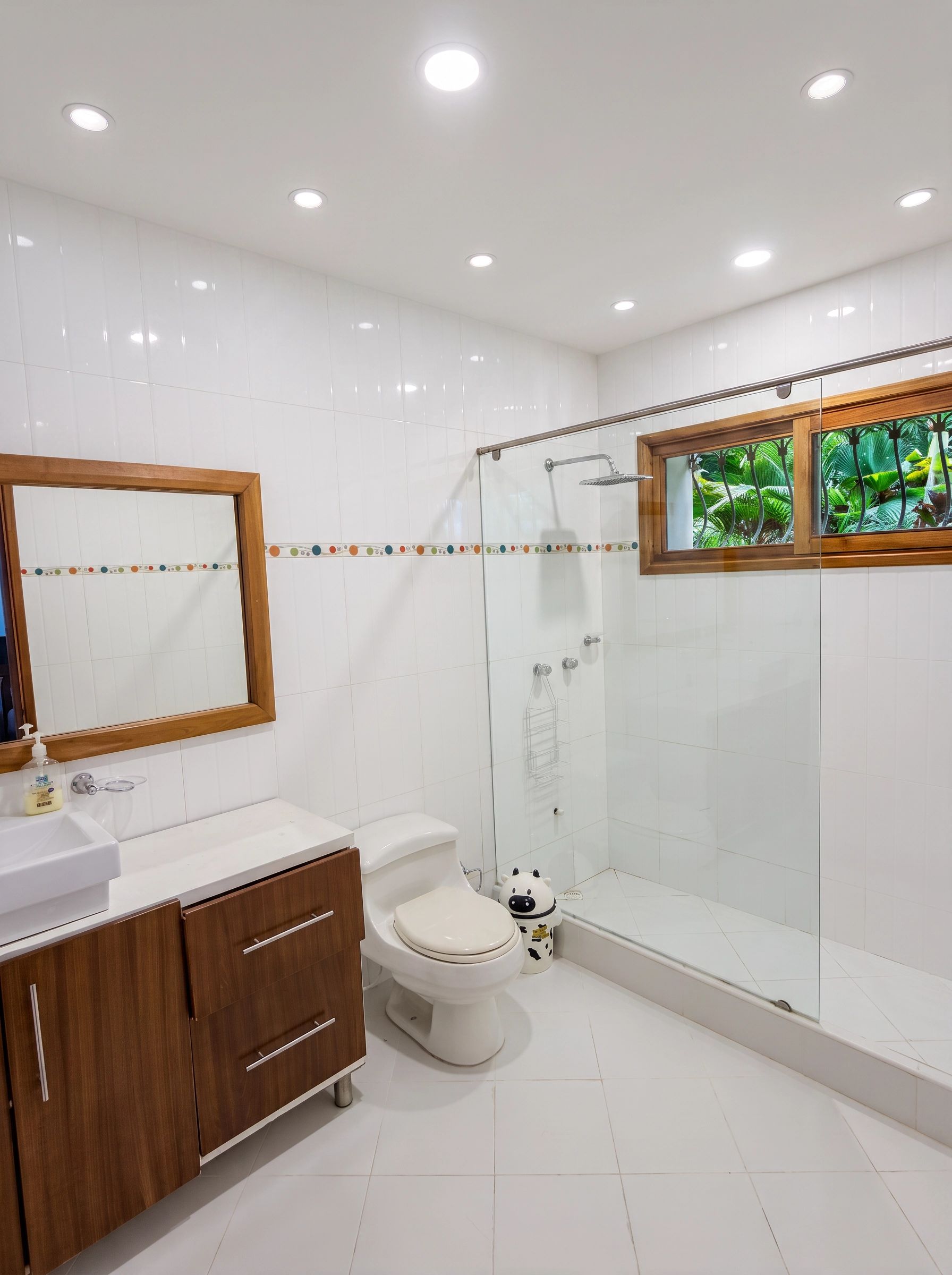 Un baño moderno con inodoro, lavamanos y zona de ducha.