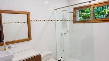 Un baño moderno con inodoro, lavamanos y zona de ducha.