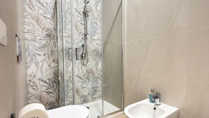 A bathroom with a glass shower enclosure, a toilet, a bidet, and a trash bin. - B&B Int'O'Vico – Deluxe Double Room 6 with Wi-Fi and Air Conditioning (Napoli)