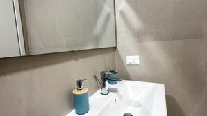 A bathroom with a white sink, a blue soap dispenser, and a mirror above it. - B&B Int'O'Vico – Deluxe Double Room 6 with Wi-Fi and Air Conditioning (Napoli)