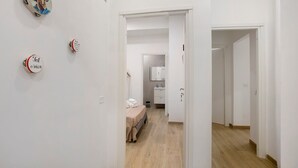 A hallway with a bed and a bathroom visible through an open door. - B&B Int'O'Vico – Standard Double Room 28 with Wi-Fi and Air Conditioning (Napoli)