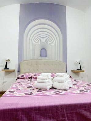 A hotel room with a bed, a headboard with a unique design, and a bedside table with a lamp. - B&B Int'O'Vico – Standard Double Room 28 with Wi-Fi and Air Conditioning (Napoli)