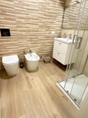A modern bathroom with a toilet, bidet, vanity, and a glass shower enclosure. - B&B Int'O'Vico – Standard Double Room 28 with Wi-Fi and Air Conditioning (Napoli)