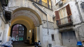 An arched doorway leading to a building with a parked scooter and a motorcycle. - B&B Int'O'Vico – Premium Double Room 29 with Balcony, Wi-Fi & Air Conditioning (Napoli)