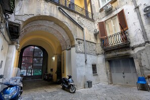 An arched doorway leading to a building with a parked scooter and a motorcycle. - B&B Int'O'Vico – Premium Double Room 29 with Balcony, Wi-Fi & Air Conditioning (Napoli)