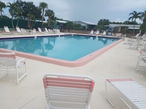 Piscina com espreguiçadeiras e placa indicando que não é permitido nadar.