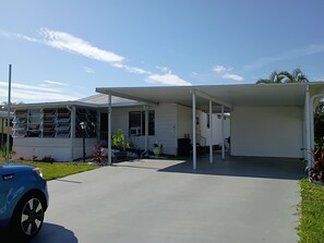 Ein eingeschossiges Haus mit überdachter Veranda, Garage und Auffahrt.