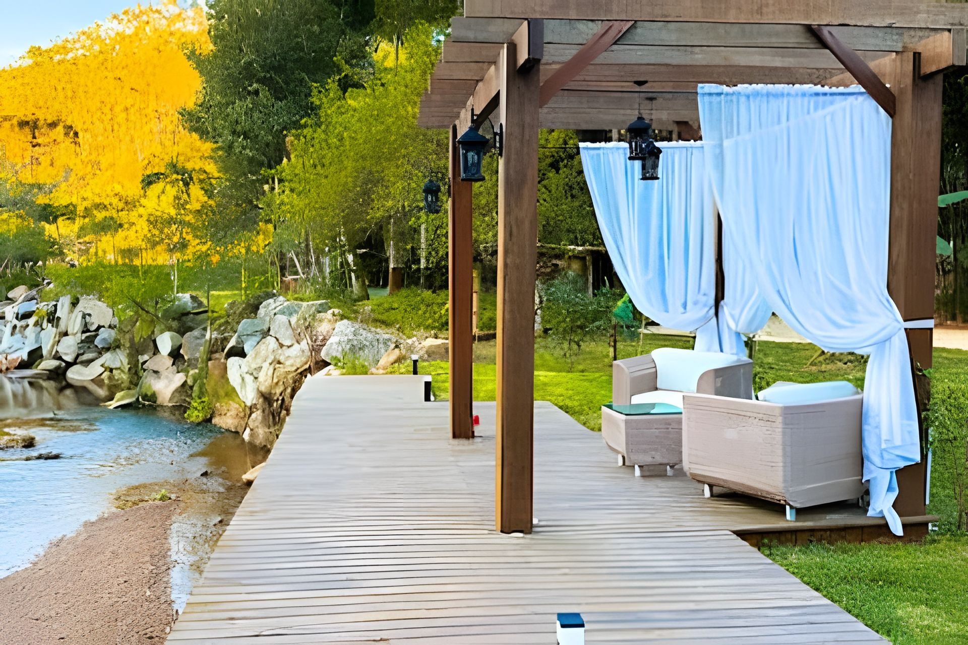 Un terrazzo in legno con posti a sedere all'aperto e vista su un fiume.