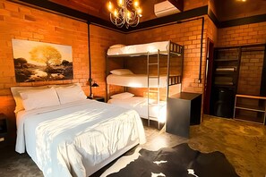 A room with a bunk bed, a single bed, a chandelier, a painting, and a brick wall. - ASA Quinta da Esmeralda Bar Pool Cabins (Itajai)