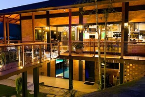A multi-level modern building with glass balconies, a pool, and a bar area. - ASA Quinta da Esmeralda Bar Pool Cabins (Itajai)