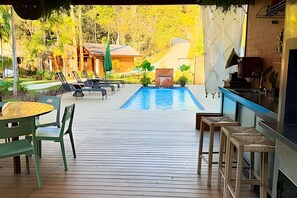 A pool area with lounge chairs, a table, and a bar. - ASA Quinta da Esmeralda Bar Pool Cabins (Itajai)