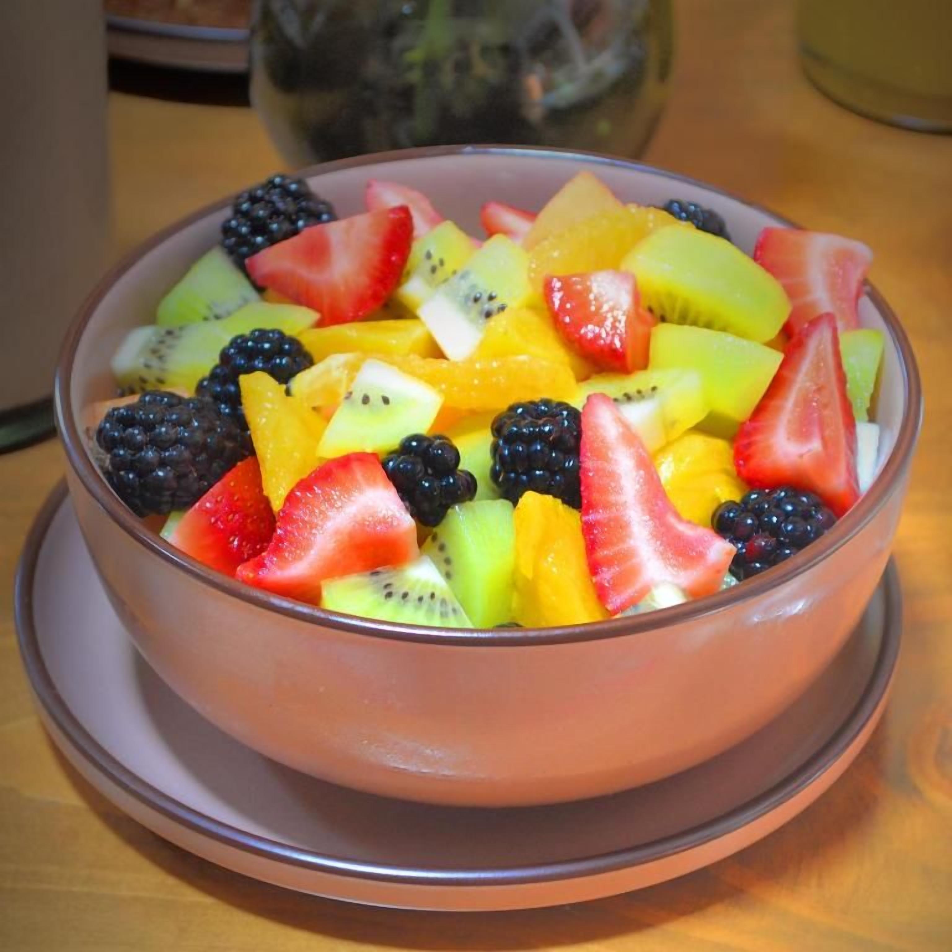 A bowl of mixed fruit salad on a table.