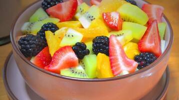 A bowl of mixed fruit salad on a table.