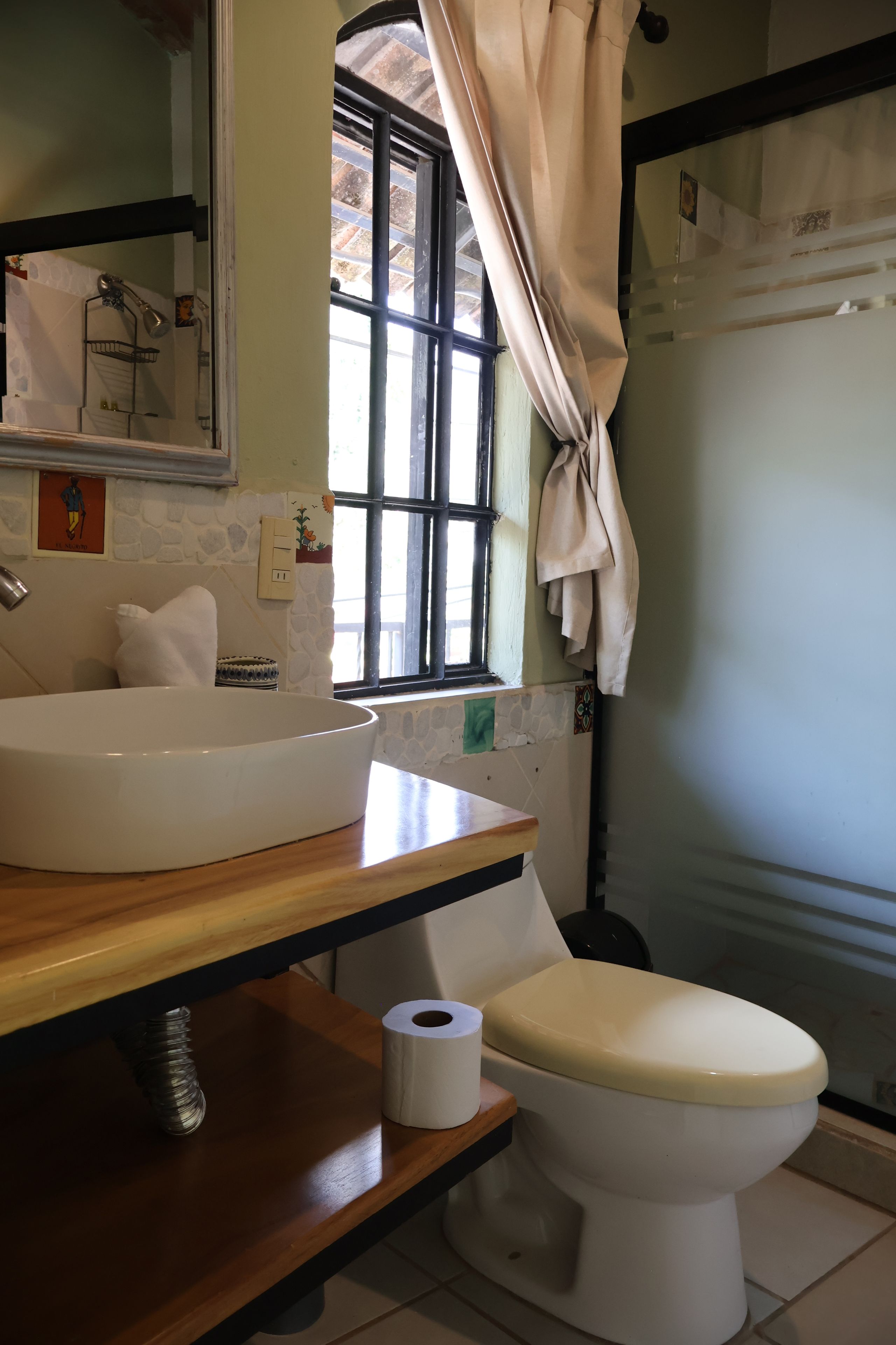 Un baño con lavamanos blanco, inodoro y zona de ducha.