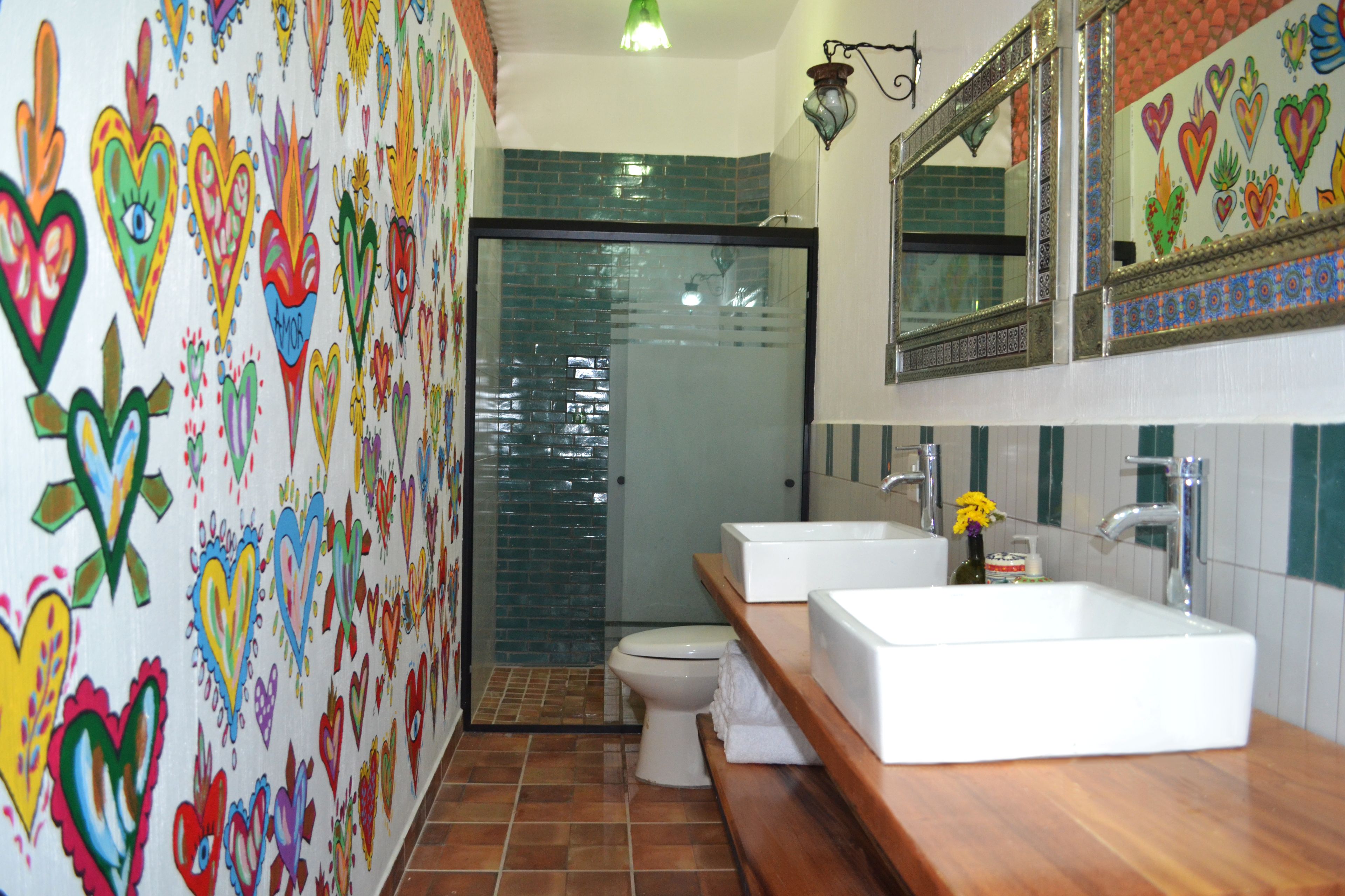 Un baño con dos lavamanos, un inodoro y una ducha.