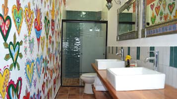 Un baño con dos lavamanos, un inodoro y una ducha.