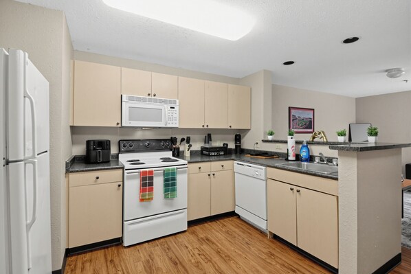A modern kitchen with a stove, microwave, oven, and dishwasher. - Spacious 4BR, 2BA Home. Mins to UC Med, Zoo & OTR (Cincinnati)
