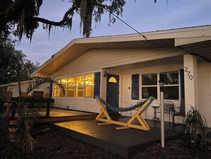 Ein Haus mit Veranda, Hängematte und Terrasse.