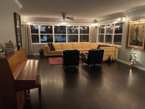 Ein Wohnzimmer mit einer Couch, zwei Sesseln, einem Couchtisch, einer Bank und einem Deckenventilator.