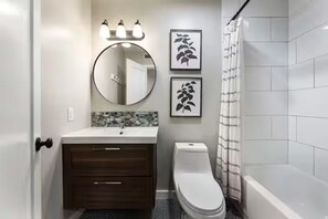 Ein Badezimmer mit Toilette, Waschbecken und Spiegel.
