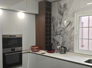A modern kitchen with built-in appliances, a window with a view, and a decorative wall. - Spacious Downtown Apartment with a Jacuzzi (Córdoba)