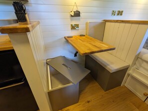 A compact kitchen with a wooden countertop, a small drawer, and a hanging light fixture.