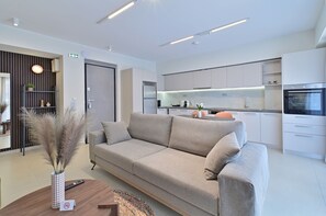 Un salon moderne avec un canapé, une table basse et un vase contenant des plantes séchées.