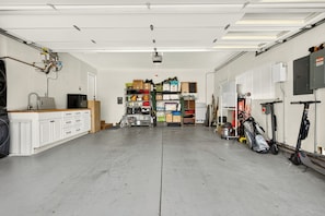 A spacious garage with a workbench, storage cabinets, and various tools and equipment. - Wine Country Escape in the heart of Yountville (Yountville)