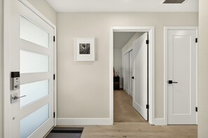 A hallway with a white door, a framed picture on the wall, and a carpeted floor. - Wine Country Escape in the heart of Yountville (Yountville)